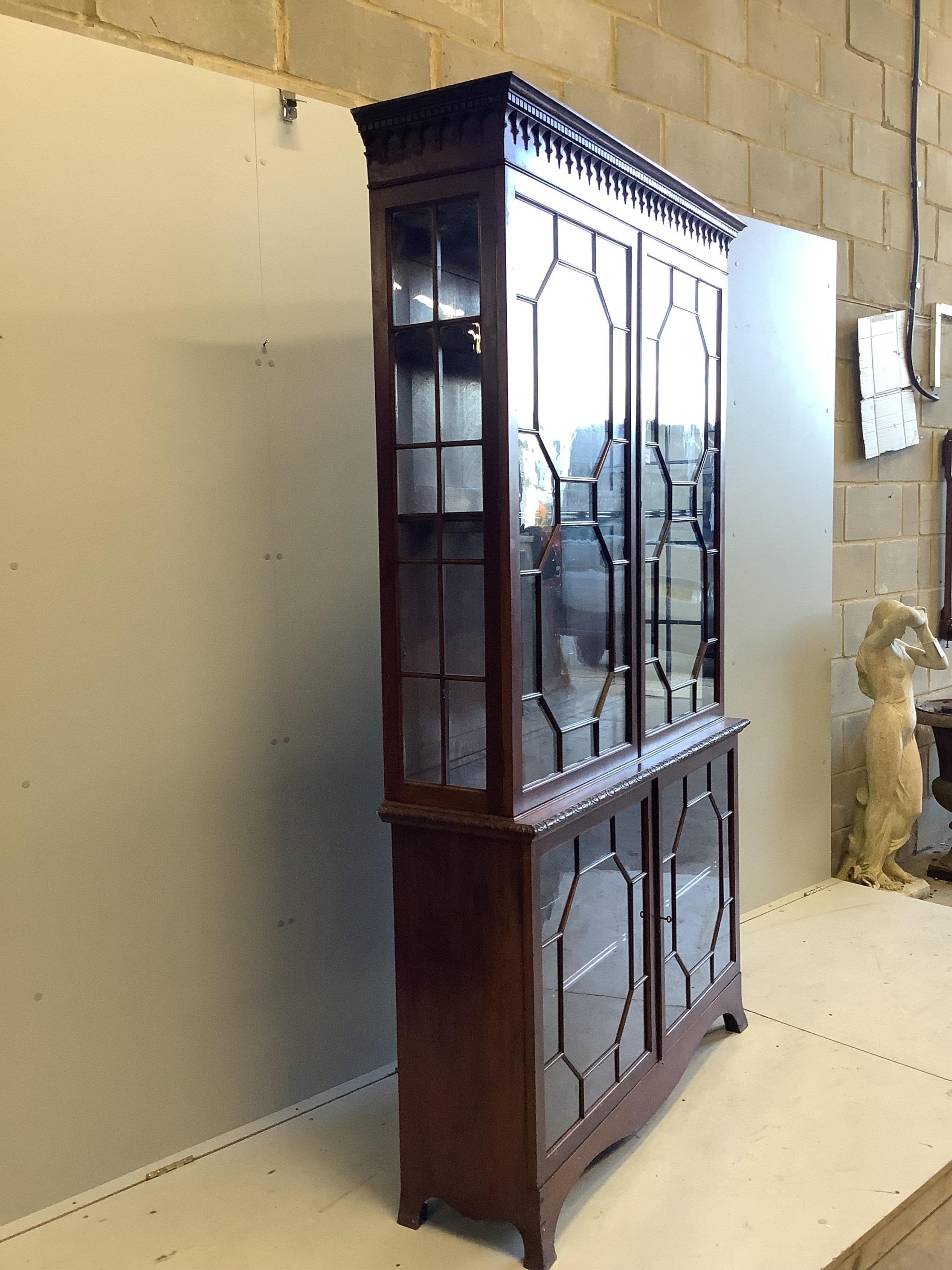 A George III style mahogany bookcase, enclosed by two pairs of astragal glazed doors, width 122cm, depth 35cm, height 214cm. Condition - fair to good